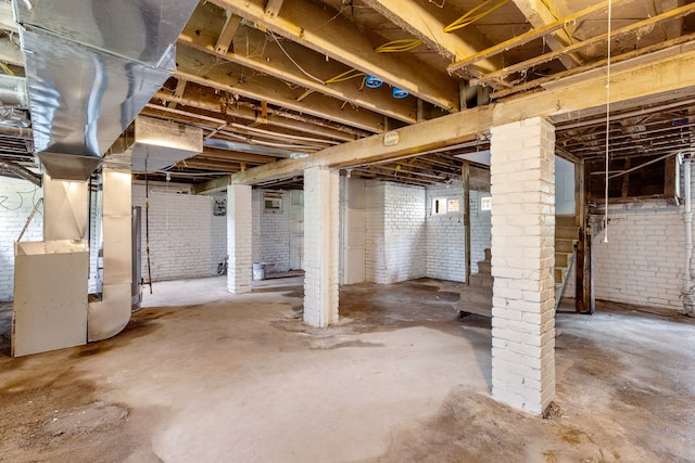 basement with brick wall and heating unit