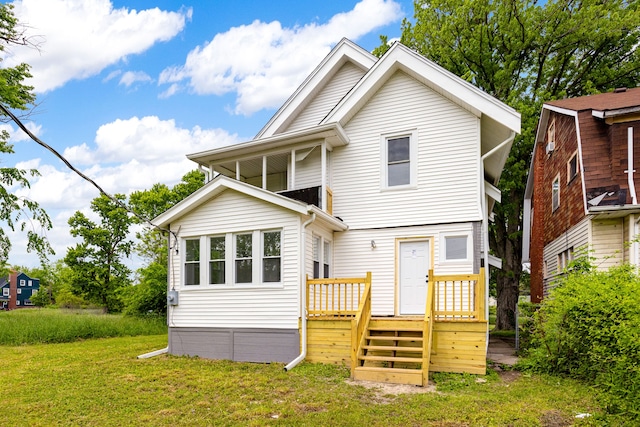 back of property with a wooden deck and a lawn