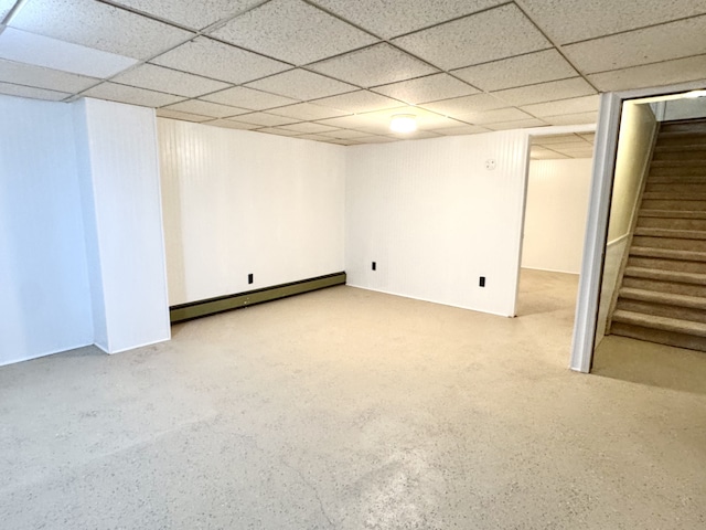 basement with a baseboard radiator and a paneled ceiling