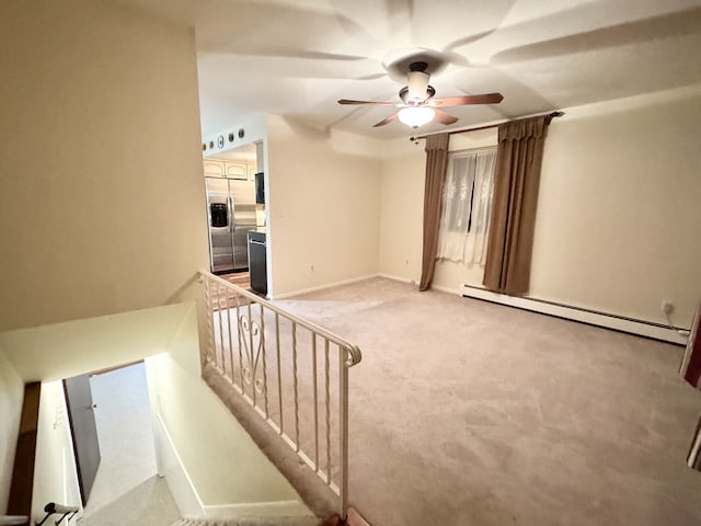 interior space with ceiling fan, a baseboard radiator, and carpet flooring