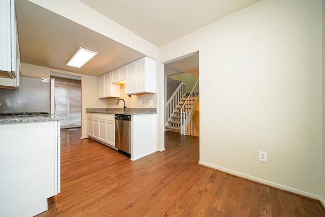 kitchen featuring light hardwood / wood-style flooring, light stone countertops, white cabinets, and appliances with stainless steel finishes