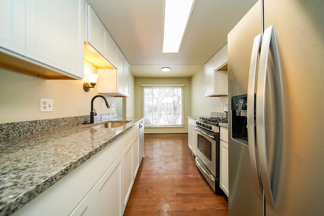 kitchen featuring appliances with stainless steel finishes, sink, white cabinets, and light stone counters