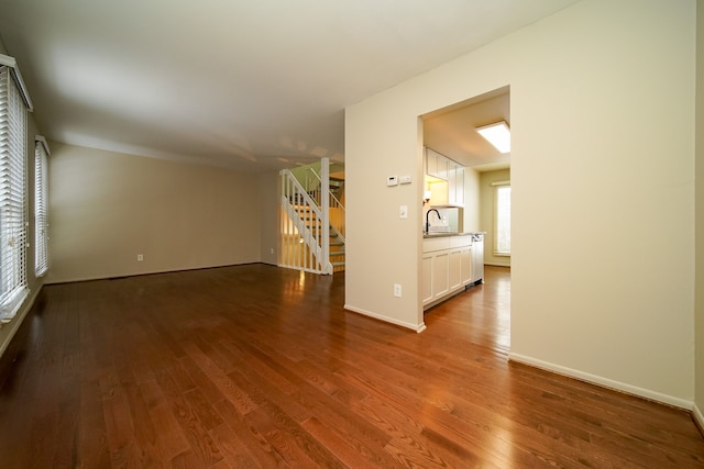 unfurnished living room with hardwood / wood-style flooring and sink