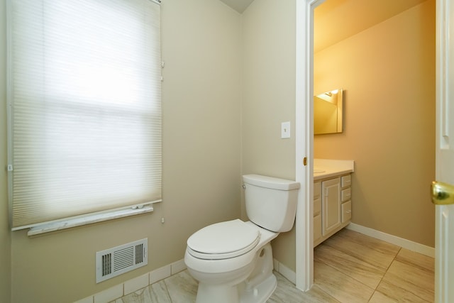 bathroom with vanity, a wealth of natural light, tile patterned floors, and toilet