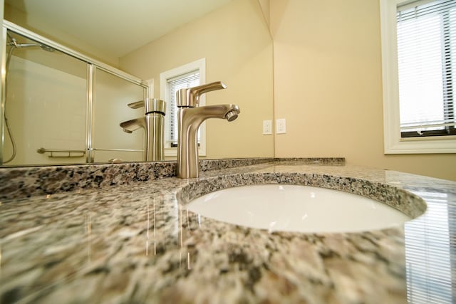 details with vanity and an enclosed shower