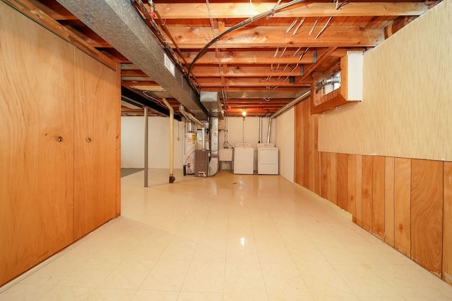 basement featuring separate washer and dryer and wooden walls