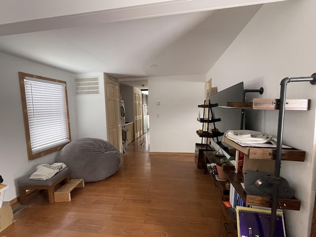 interior space with wood-type flooring and stacked washing maching and dryer