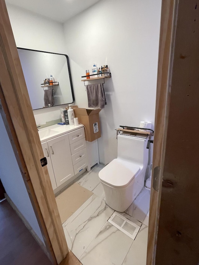 bathroom featuring vanity and toilet