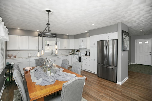 dining area featuring sink, dark hardwood / wood-style floors, and a textured ceiling