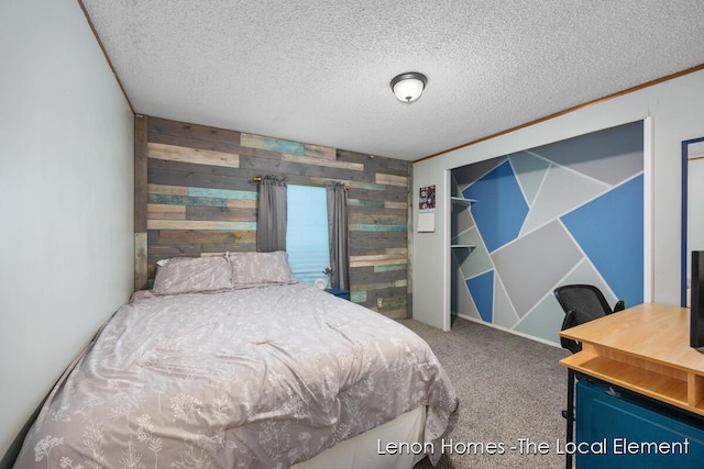 carpeted bedroom featuring a textured ceiling and wooden walls