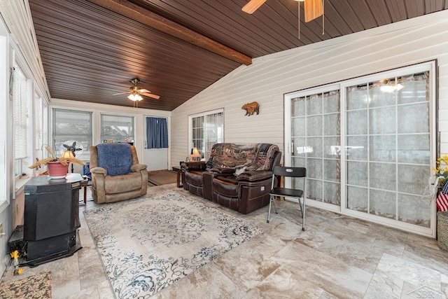 sunroom featuring vaulted ceiling with beams, a wood stove, wooden ceiling, and ceiling fan