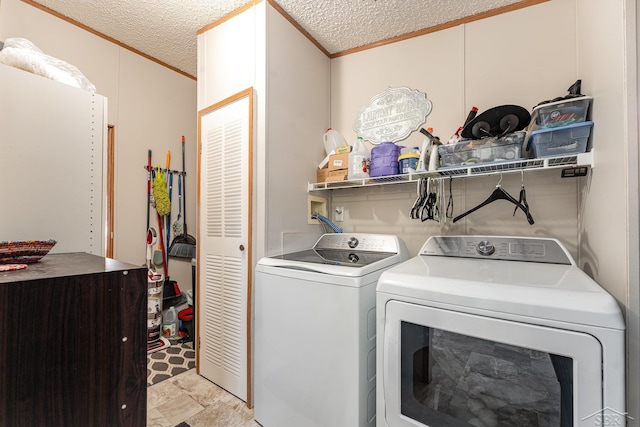 clothes washing area with crown molding, washer and dryer, and a textured ceiling