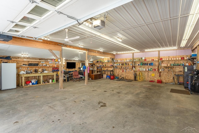 garage with a garage door opener, a workshop area, and refrigerator