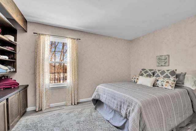 bedroom with multiple windows and light hardwood / wood-style flooring