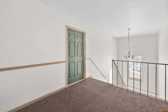 unfurnished room with carpet floors and a notable chandelier