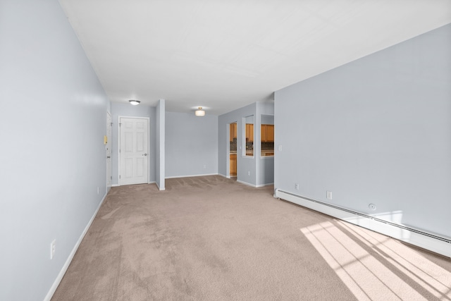 spare room featuring a baseboard heating unit and light carpet