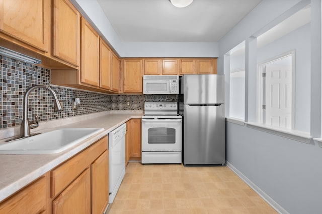 kitchen featuring sink, backsplash, and white appliances