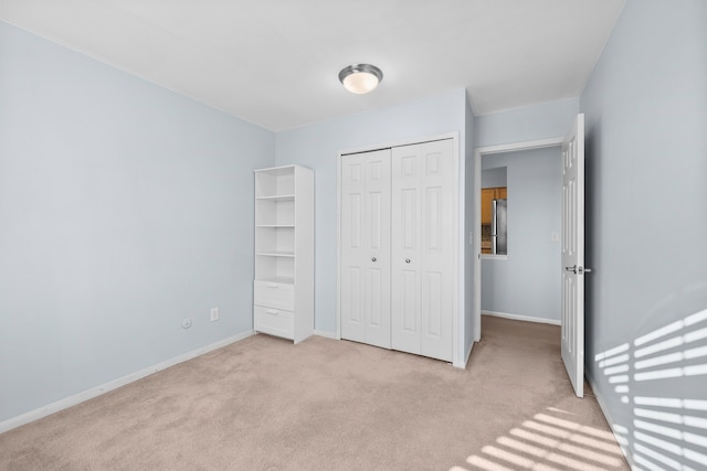 unfurnished bedroom with light carpet and a closet