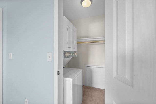 clothes washing area featuring stacked washer / drying machine and carpet floors