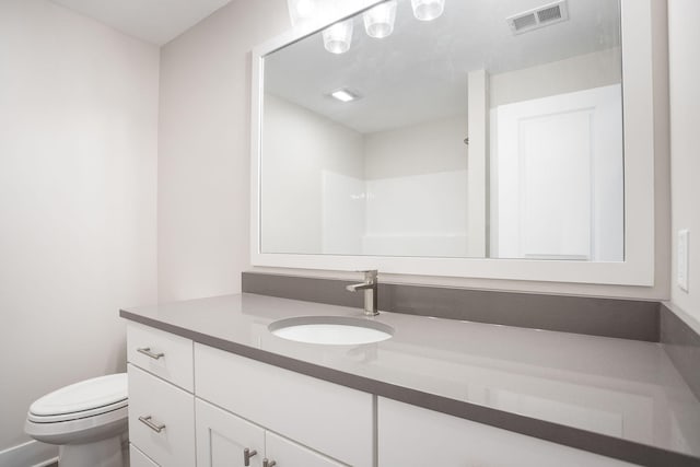 bathroom with vanity, walk in shower, and toilet