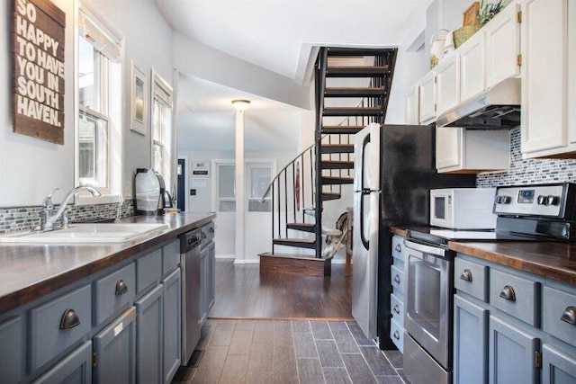 kitchen with white cabinetry, appliances with stainless steel finishes, sink, and wood counters