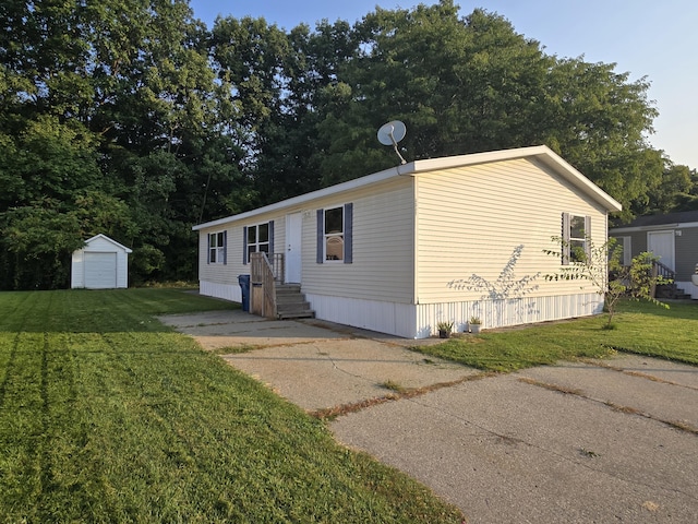 manufactured / mobile home with a storage shed and a front yard