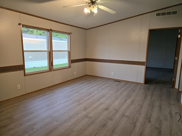 spare room with ornamental molding, ceiling fan, and light hardwood / wood-style floors