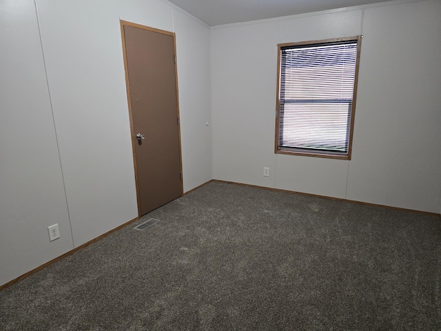 spare room featuring dark carpet