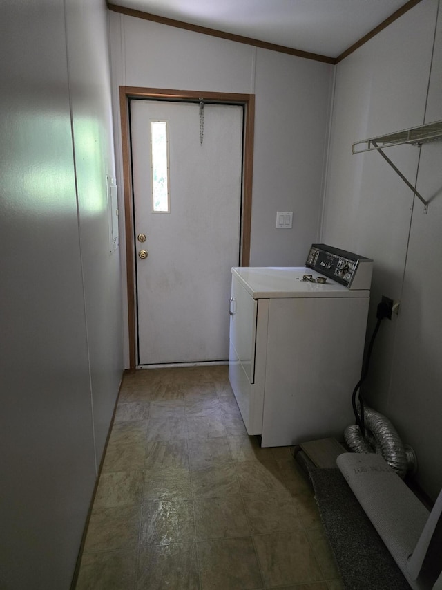 washroom with ornamental molding and washer / dryer