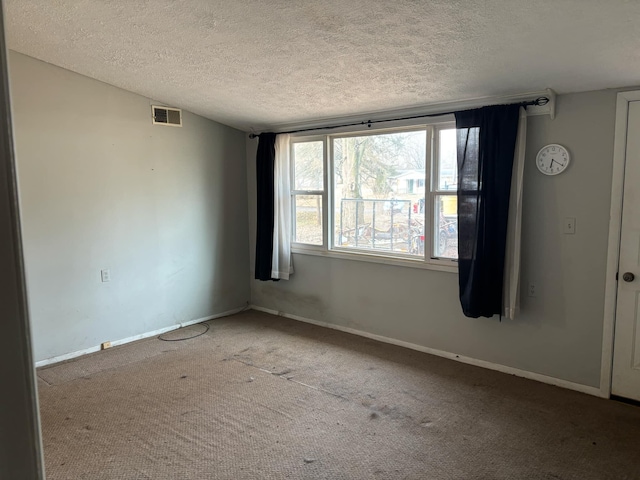 carpeted spare room featuring a textured ceiling