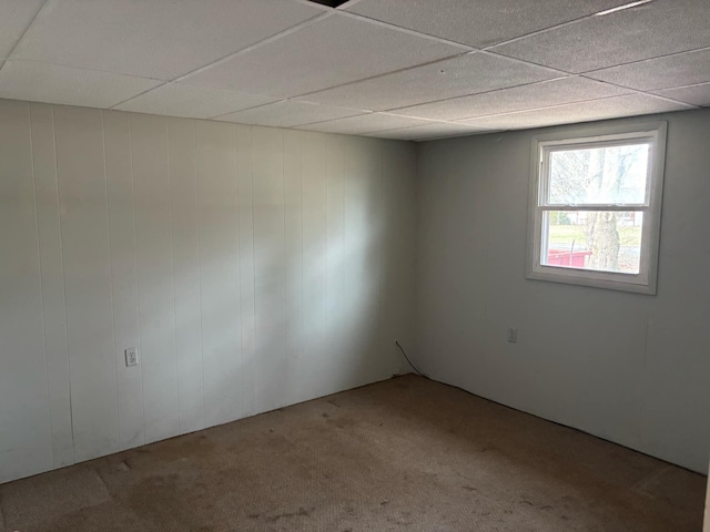 carpeted empty room with a paneled ceiling