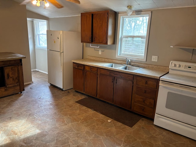 kitchen featuring lofted ceiling, sink, white appliances, and ceiling fan