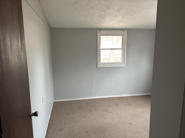 spare room featuring carpet floors and a textured ceiling