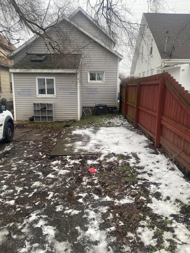 snow covered property with central AC unit