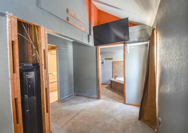 unfurnished bedroom with ensuite bathroom, lofted ceiling, and light carpet