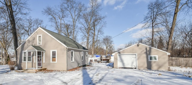 snow covered property with an outbuilding and a garage