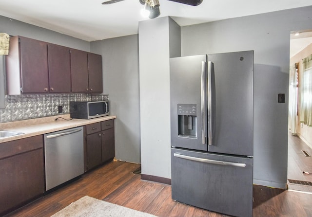 kitchen featuring appliances with stainless steel finishes, dark hardwood / wood-style floors, backsplash, ceiling fan, and dark brown cabinets