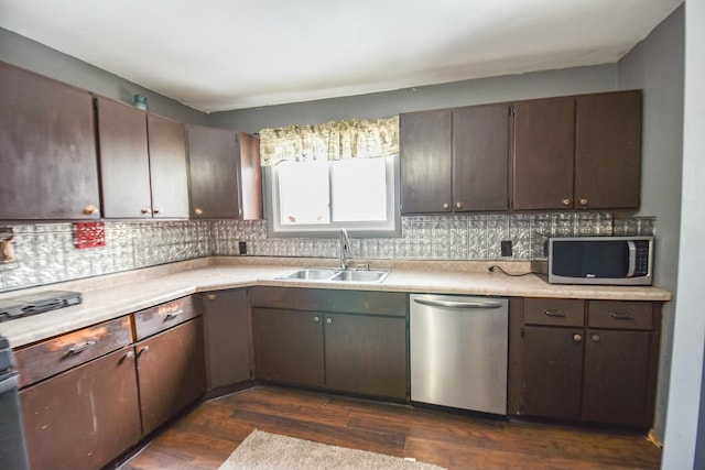 kitchen with stainless steel appliances, dark brown cabinets, and sink