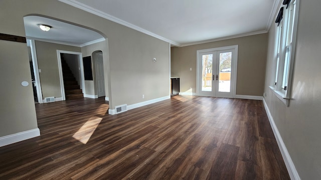 empty room with crown molding, dark wood-type flooring, and french doors