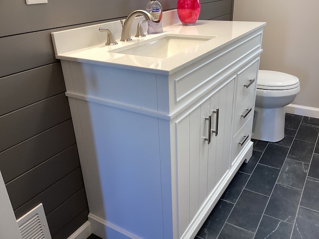 bathroom with tile patterned flooring, vanity, and toilet