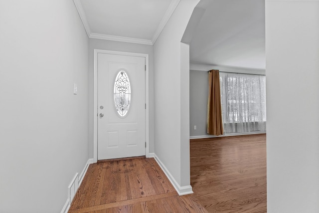 foyer entrance with hardwood / wood-style floors and crown molding