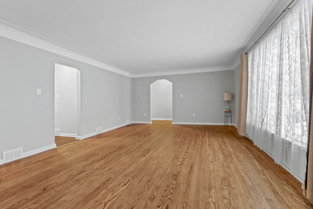 empty room featuring ornamental molding and light hardwood / wood-style floors