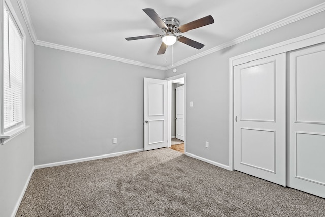 unfurnished bedroom with crown molding, light colored carpet, a closet, and ceiling fan