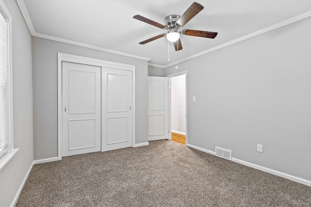 unfurnished bedroom with ceiling fan, a closet, ornamental molding, and carpet