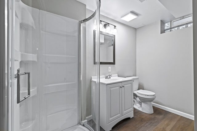 bathroom featuring hardwood / wood-style flooring, vanity, toilet, and a shower with shower door