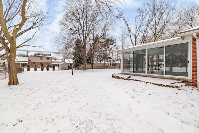 yard covered in snow with a sunroom