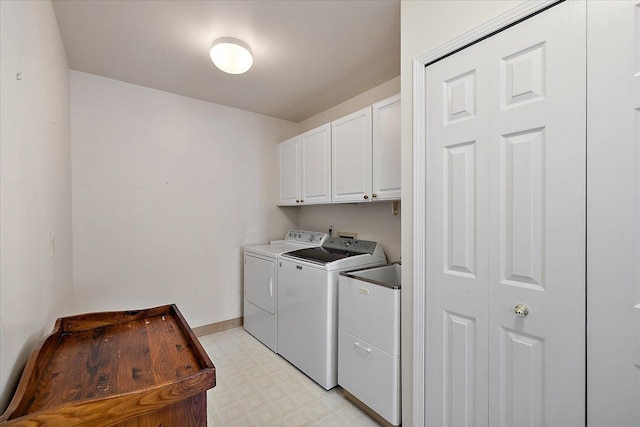 washroom with cabinets and washer and dryer