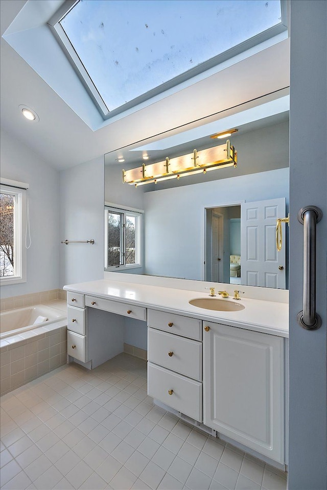 bathroom with vanity, lofted ceiling, a relaxing tiled tub, and tile patterned floors