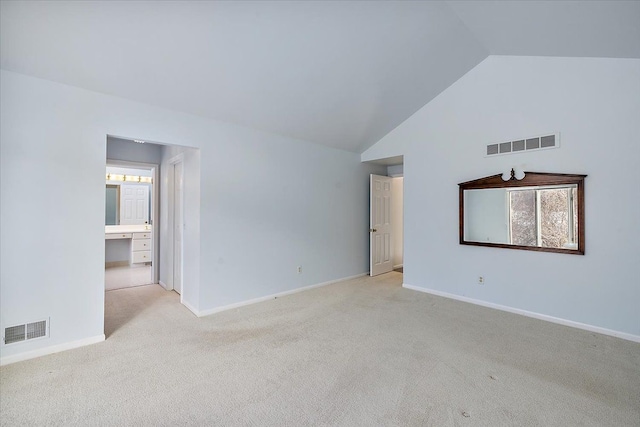 carpeted spare room with high vaulted ceiling