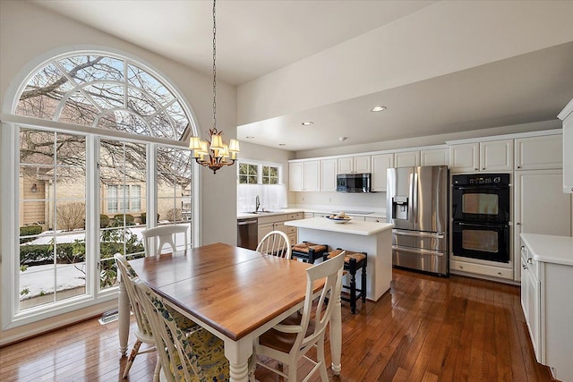 dining space with dark hardwood / wood-style flooring, a chandelier, and sink